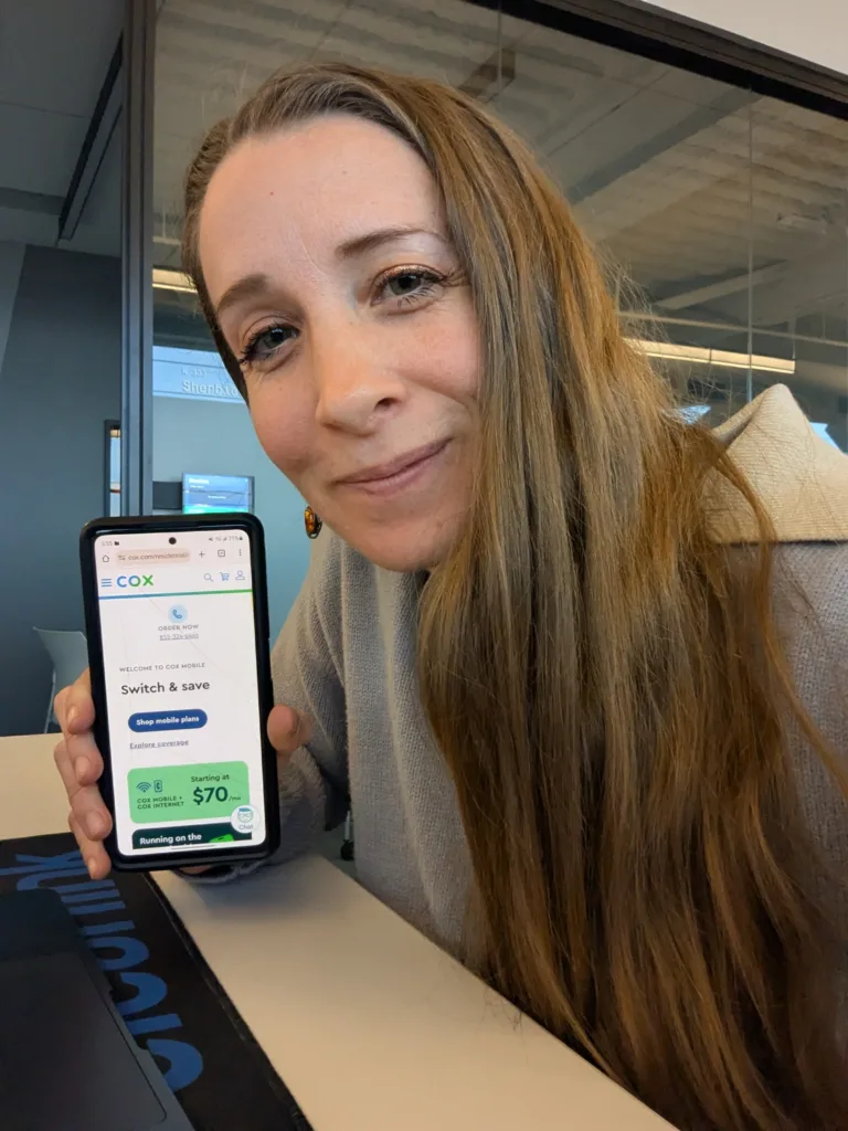 Staff Writer displaying Cox Mobile plans on Cox website on a mobile phone.