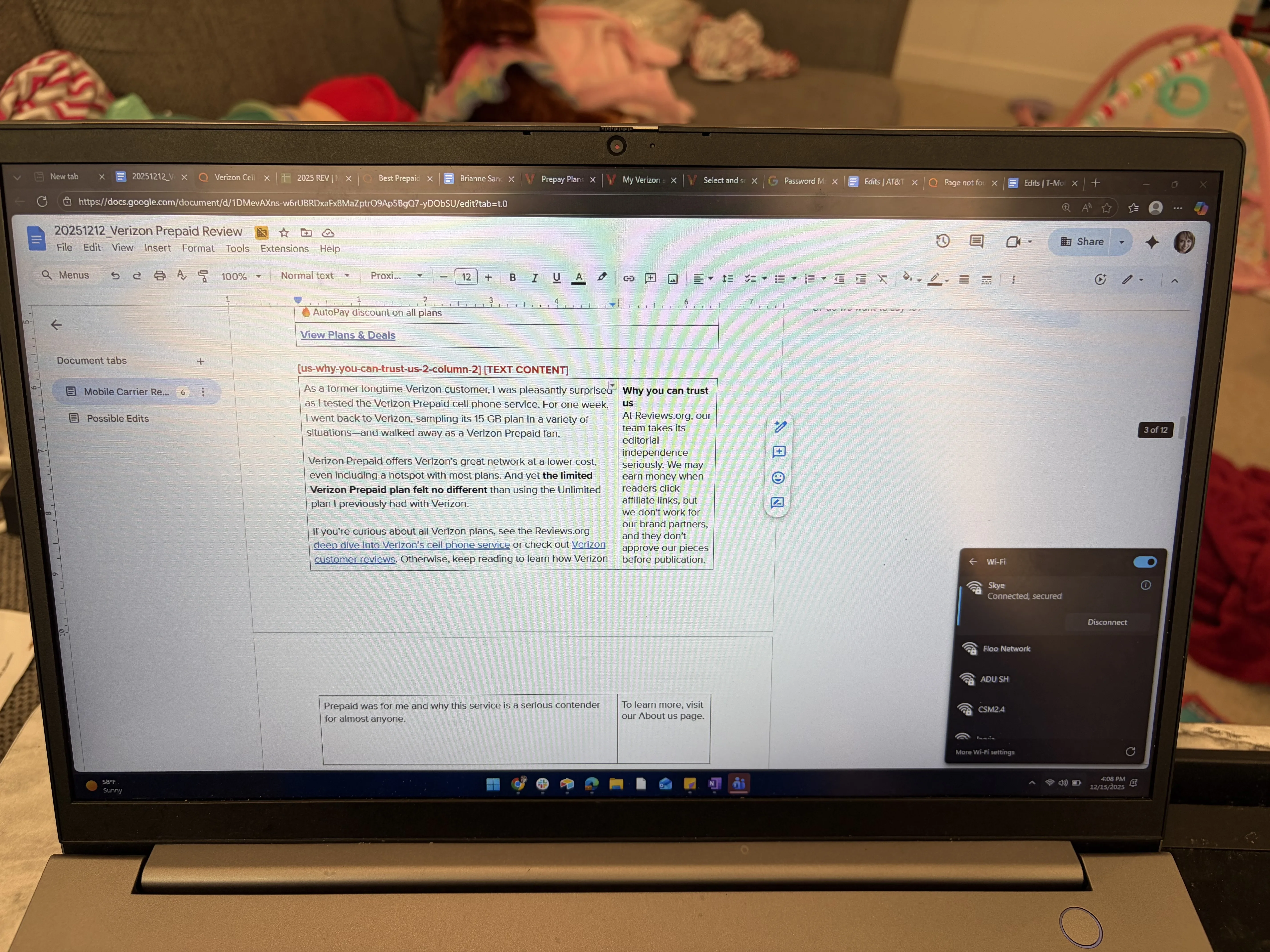 A laptop showing a Google Docs draft of a Verizon Prepaid review