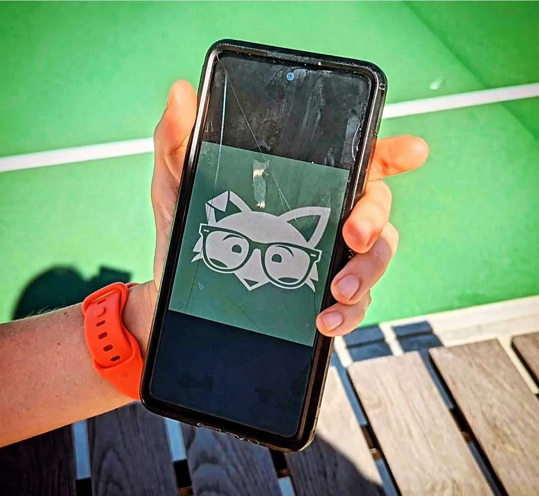 Image of a hand holding a phone showing the Mint Mobile fox mascot