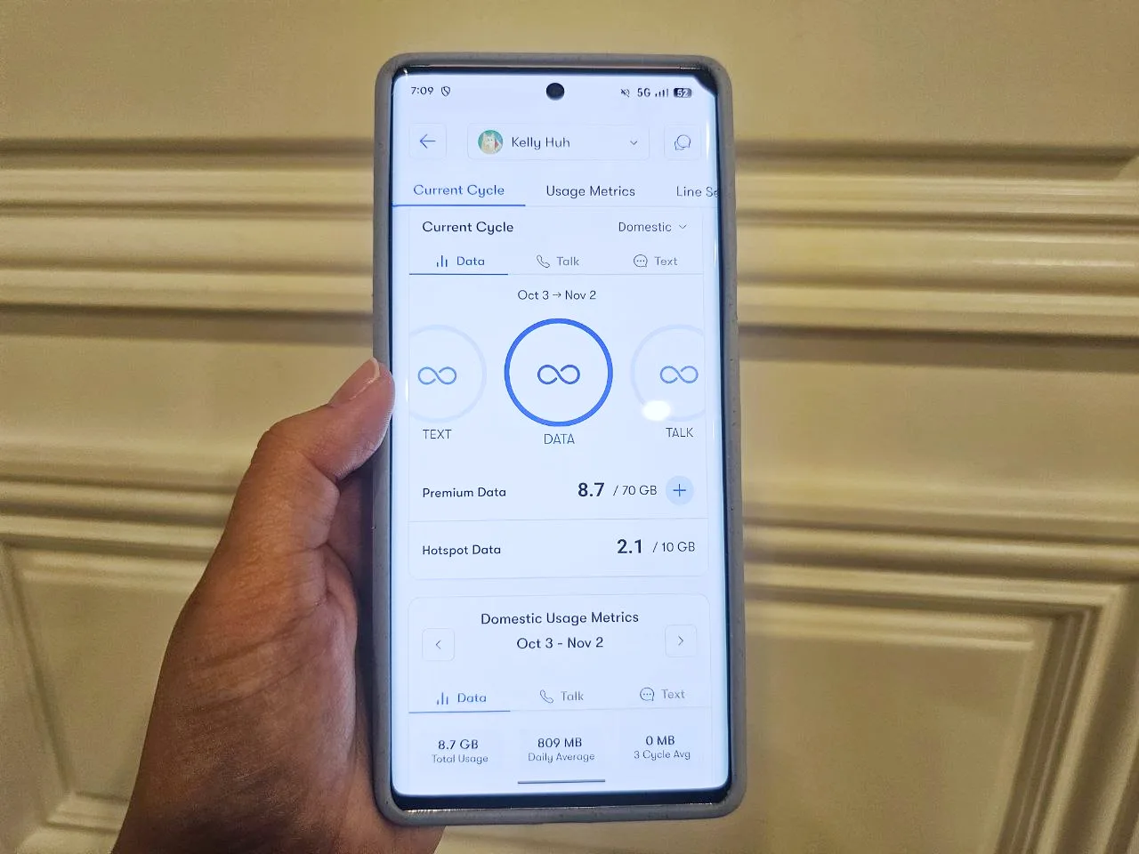 Image of a hand holding a phone showing the US Mobile app