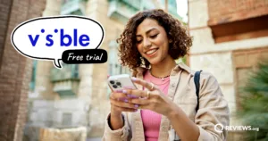Woman smiling while using her phone outdoors, with a speech bubble showing the Visible logo and 'Free trial' text.