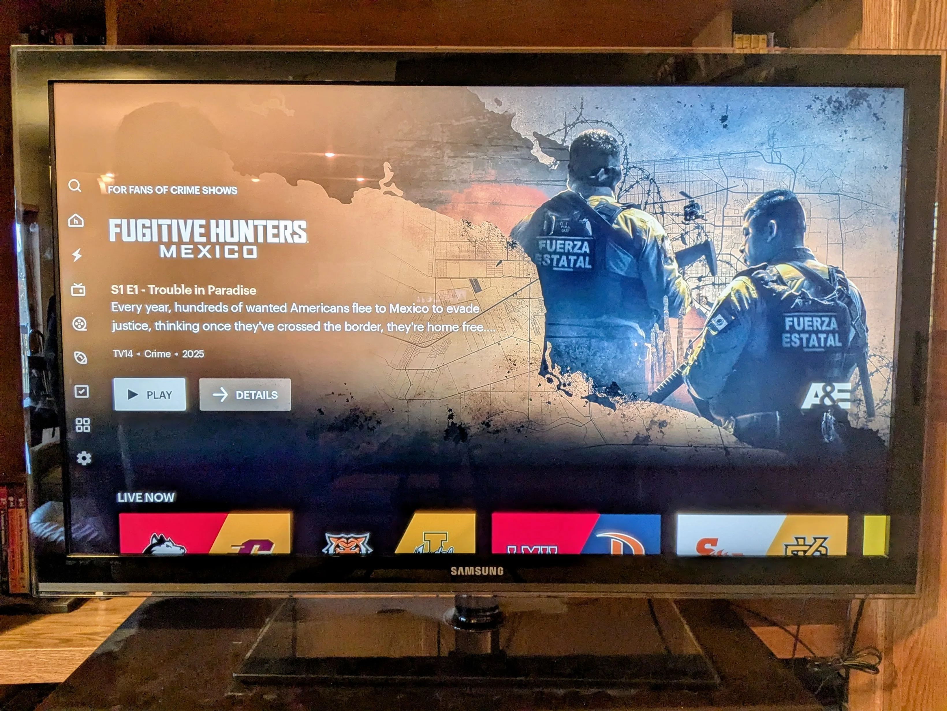 TV screen showing the Hulu + Live TV home page with teaser trailer and navigation buttons to the left.