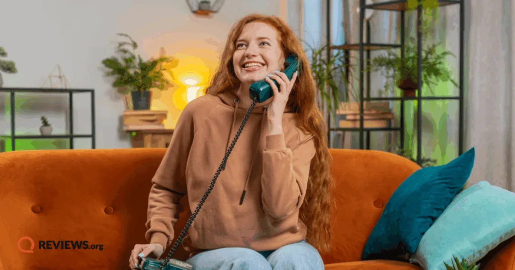 Woman making a phone call on a landline phone.