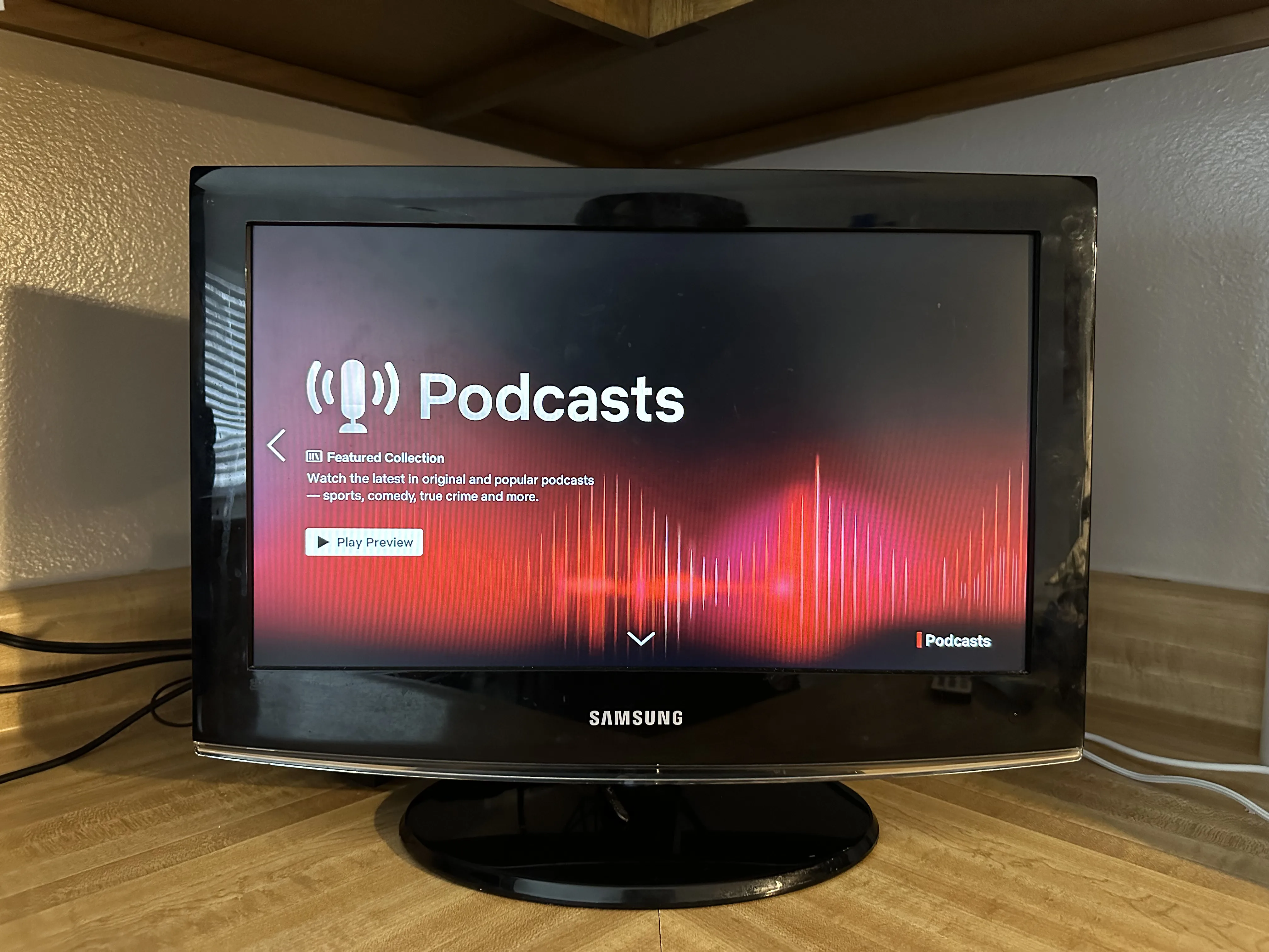 A photo of a Samsung smart TV displays the Netflix app. On screen, the preview for a new category titled ‘Podcasts’ is displayed.