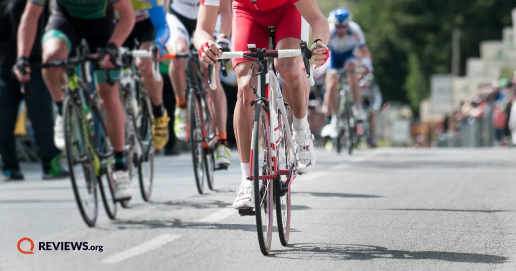 Group of cyclists competing in a road race during the Tour de France, photographed from a low angle on the course.
