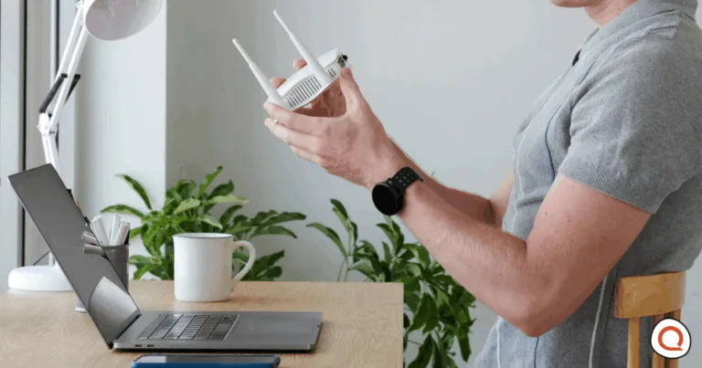 Man holding and inspecting at-home WiFi router while working from home. Image credit: iStock/DragonImages