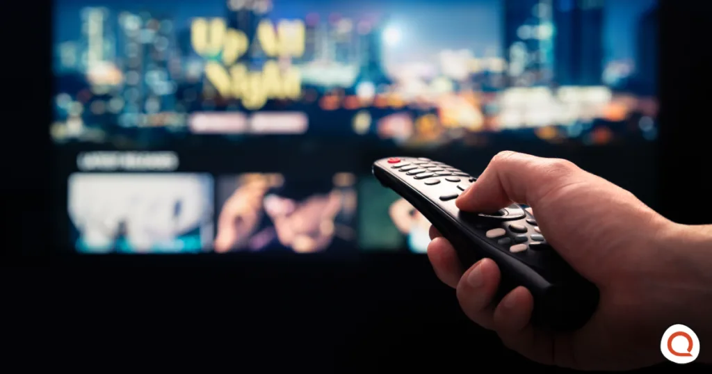 Person holding TV remote while browsing Netflix on screen considering canceling subscription after price increase