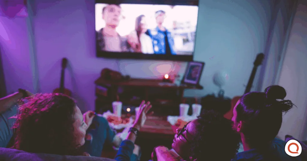 Group of friends gathered together to watch live TV event in real time. Image Credit: iStock/wundervisuals