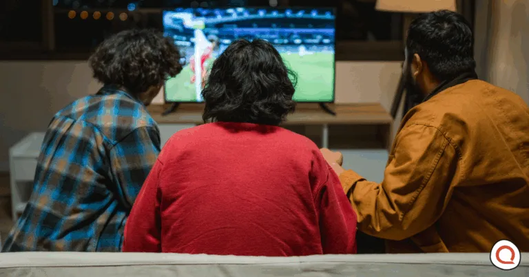 Group of people sitting and watching sports on TV