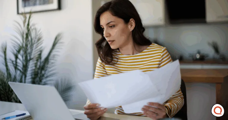 Woman reviewing finances at a desk in her home. Image credit: iStock/damircudic