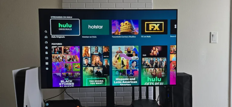 A photo of a television screen taken for Reviews.org’s Hulu review. displaying the Hulu streaming interface, showing channel Hubs including Hulu Originals, Hotstar on Hulu, Twentieth Century Studios, and FX on Hulu across the top row.