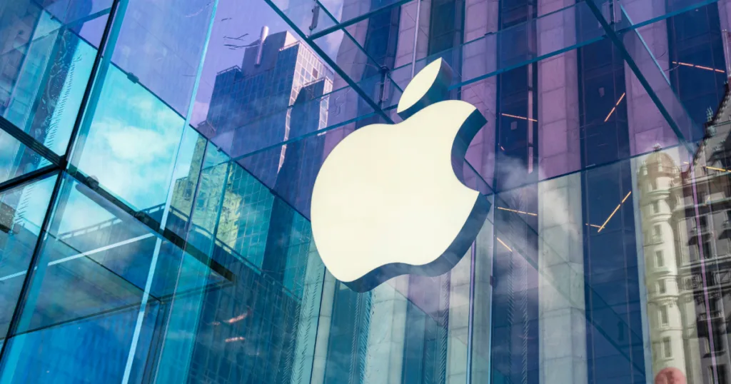 Apple store with the city skyline reflected off the glass of the building.