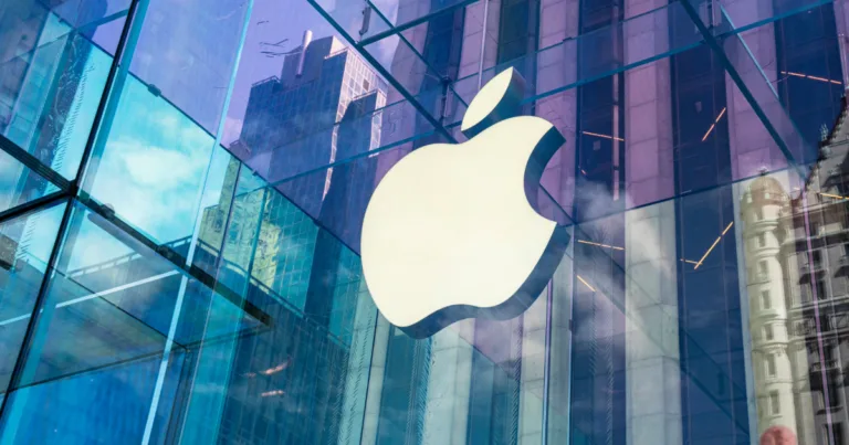 Apple store with the city skyline reflected off the glass of the building.