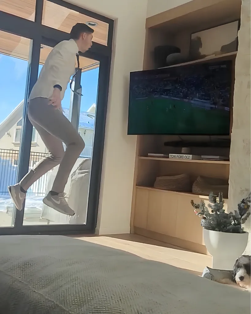 Person jumping in the air and watching a television screen