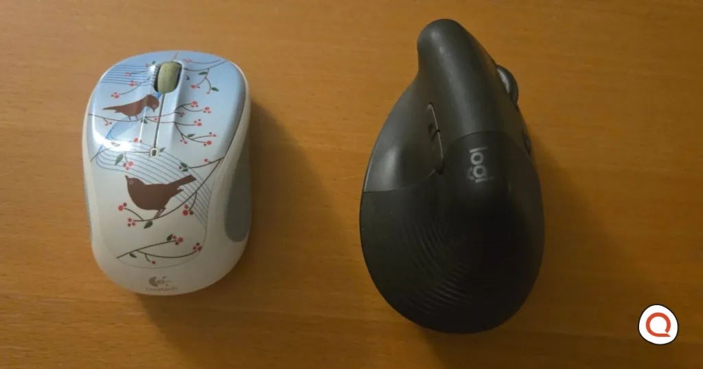 A side-by-side display of a Logitech M325 Wireless and a Lift Vertical Ergonomic mouse. The M325 has a blue design that is decorated with birds on a branch. The Lift Vertical has a graphite color.