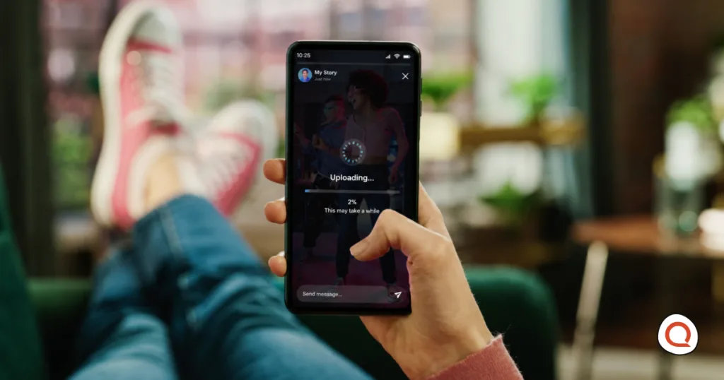 A person holding a phone showing a story upload stuck at 2%, illustrating slow social media upload speeds.