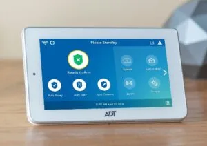 ADT Command touchscreen panel displaying the home security control interface with arming options and smart home controls