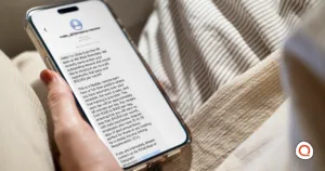 A person holds a phone displaying a scam text message offering a suspicious high-paying remote job, illustrating common text message scams.