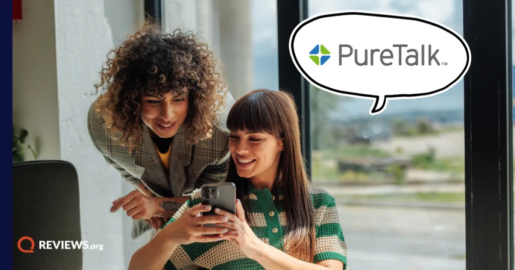 Two people gather and look at a PureTalk cell phone device