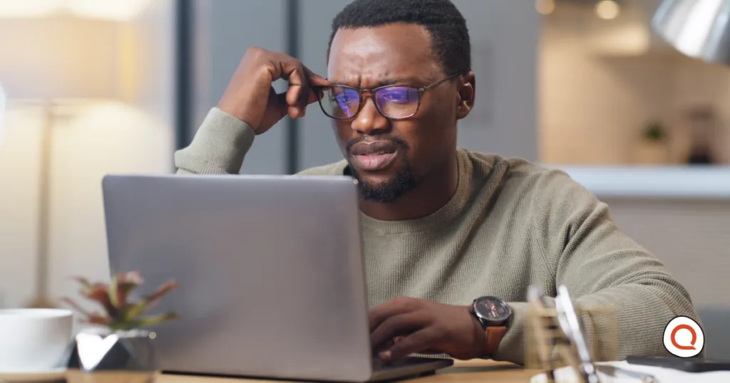 A confused man reviewing something on his laptop, questioning whether T-Mobile's new backup internet limits still work in his favor.