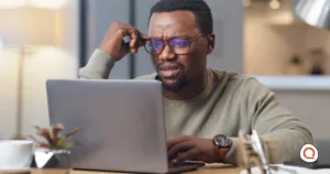 A confused man reviewing something on his laptop, questioning whether T-Mobile's new backup internet limits still work in his favor.