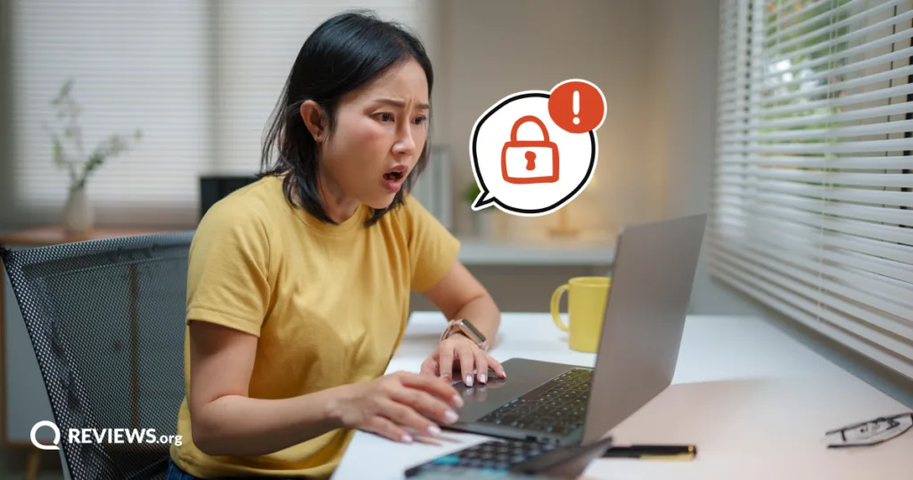 A shocked woman stares at her laptop after spotting signs of a hacked account, the moment to act fast and secure her devices.
