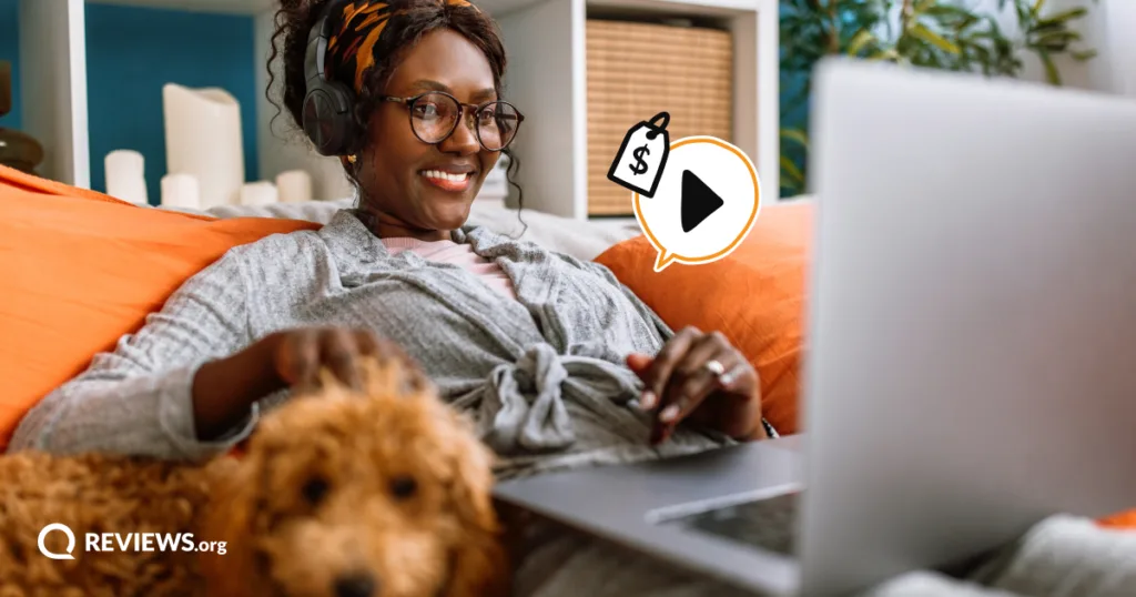Smiling woman with headphones streams on her laptop beside her dog, with a play button and price tag representing ways to stream for free.